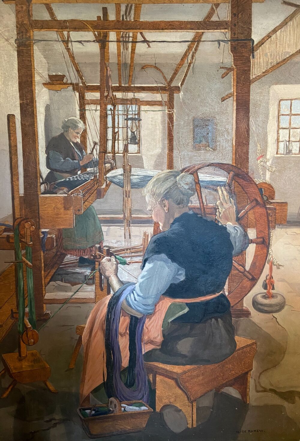 An oil painting of two women sitting at a large wooden loom, weaving. The woman in the foreground is spinning green thread through a spinning wheel. The woman in the background is operating the wooden foot pedals of the loom.