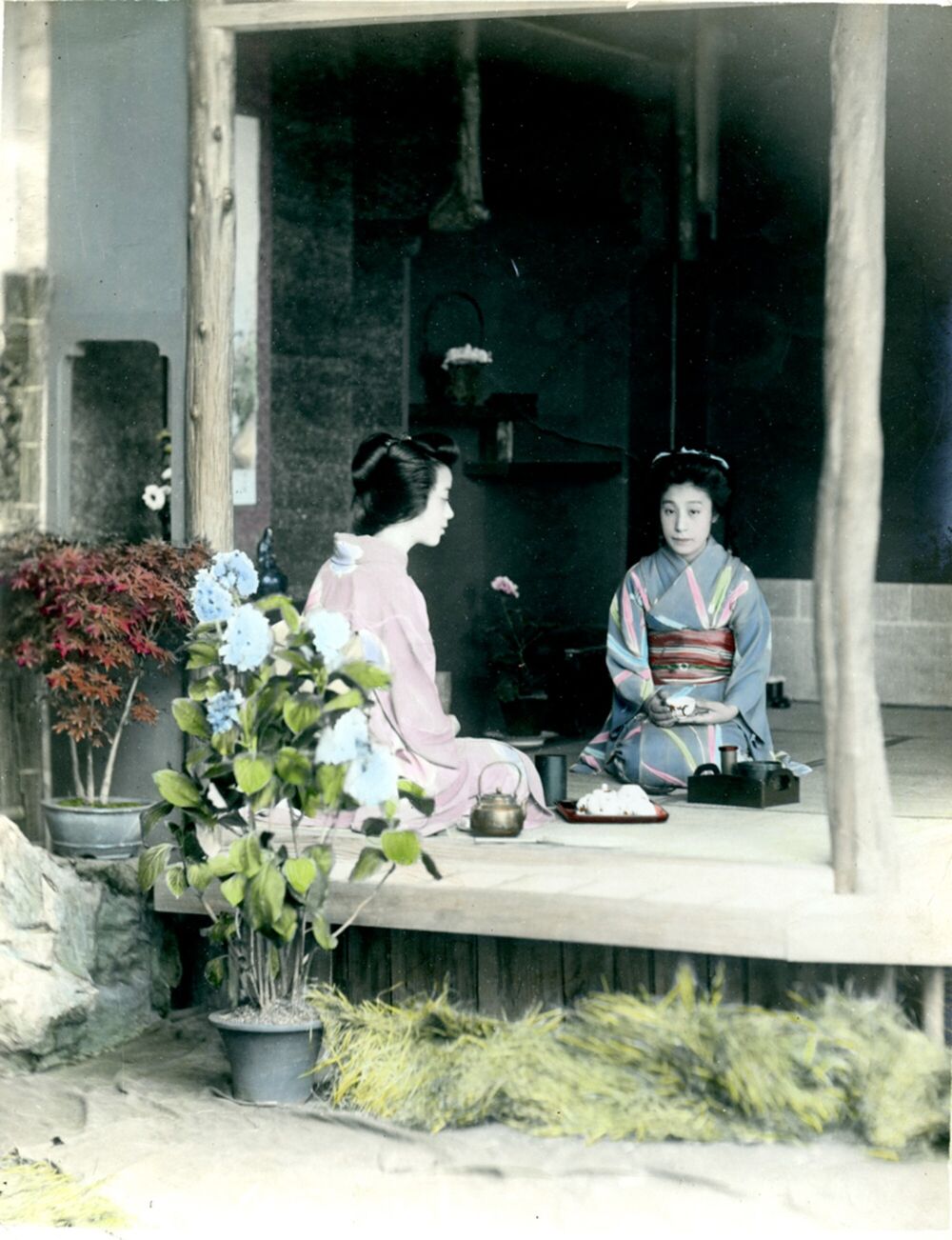 Coloured print showing a Japanese tea ceremony, with two women in Japanese costume.