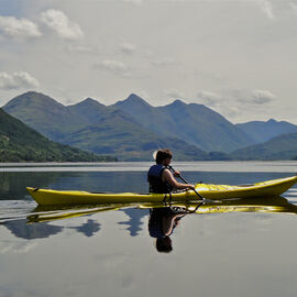 A person enjoying sea kayaking in Loch Duich by Kintail