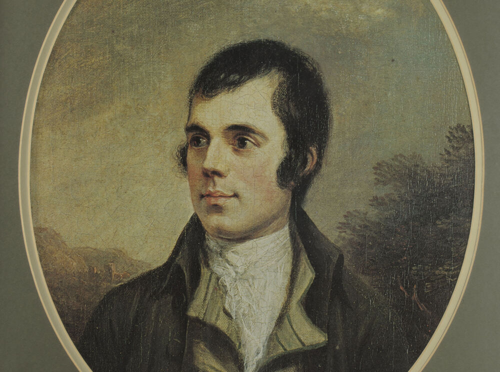 A close-up of an oval portrait of the head and shoulders of Robert Burns. He is shown standing against a natural backdrop.