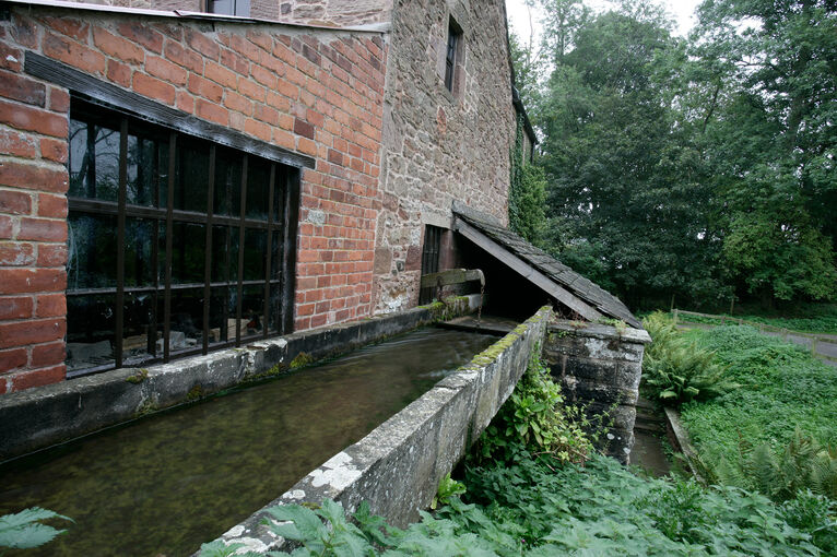 Water flowing along a wooden trough by the side of the mill
