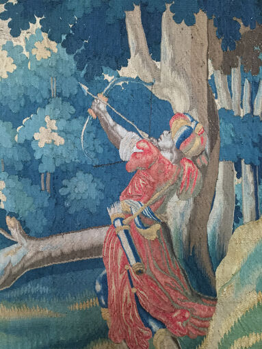 Detail in a tapestry of an archer, before cleaning