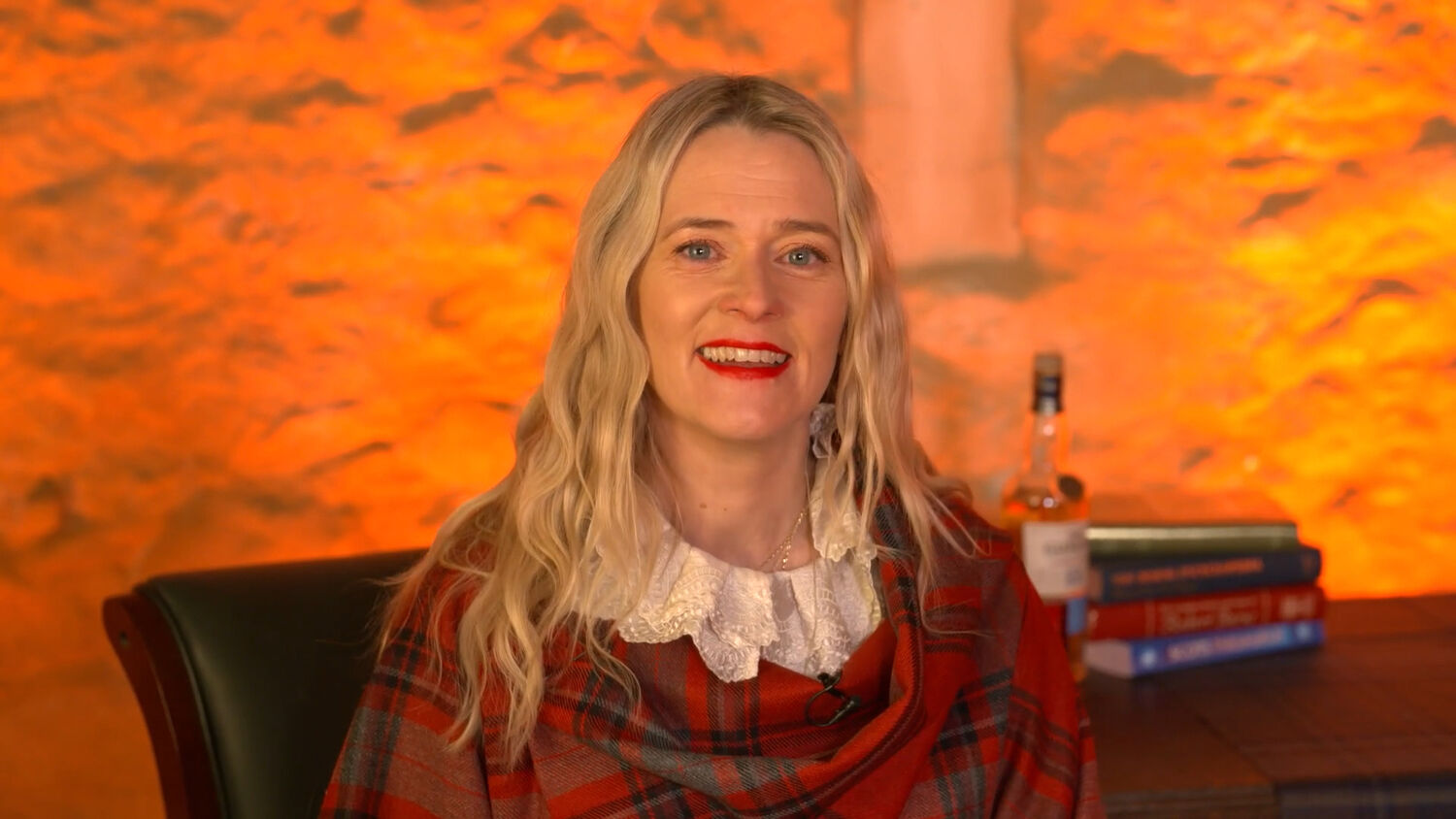 Woman in red tartan top sitting in cosy cottage