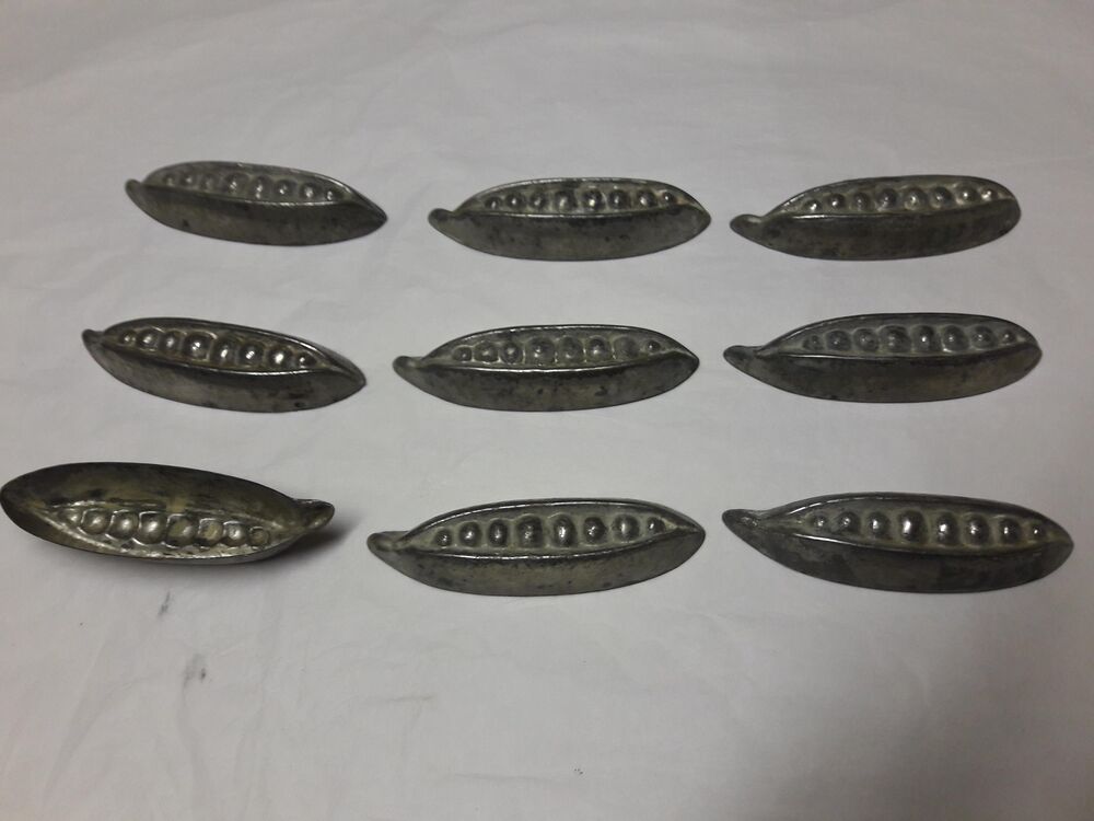 Nine small tin moulds, shaped like pea pods, are arranged in a 3x3 format against a plain grey background.