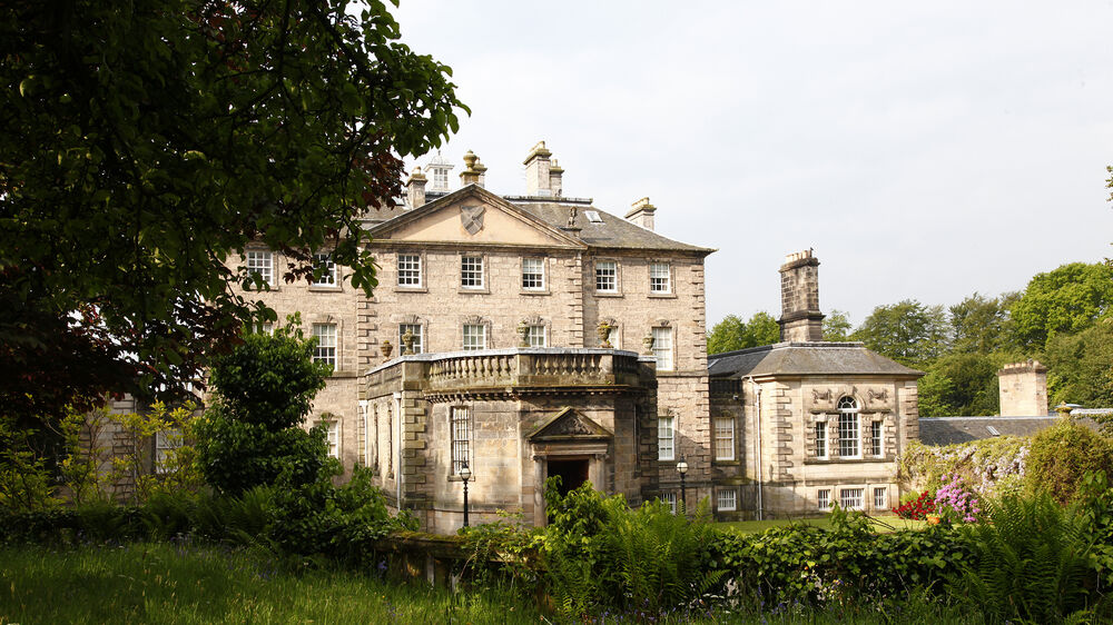 A view of the entrance to Pollok House, seen from the surrounding woodland.