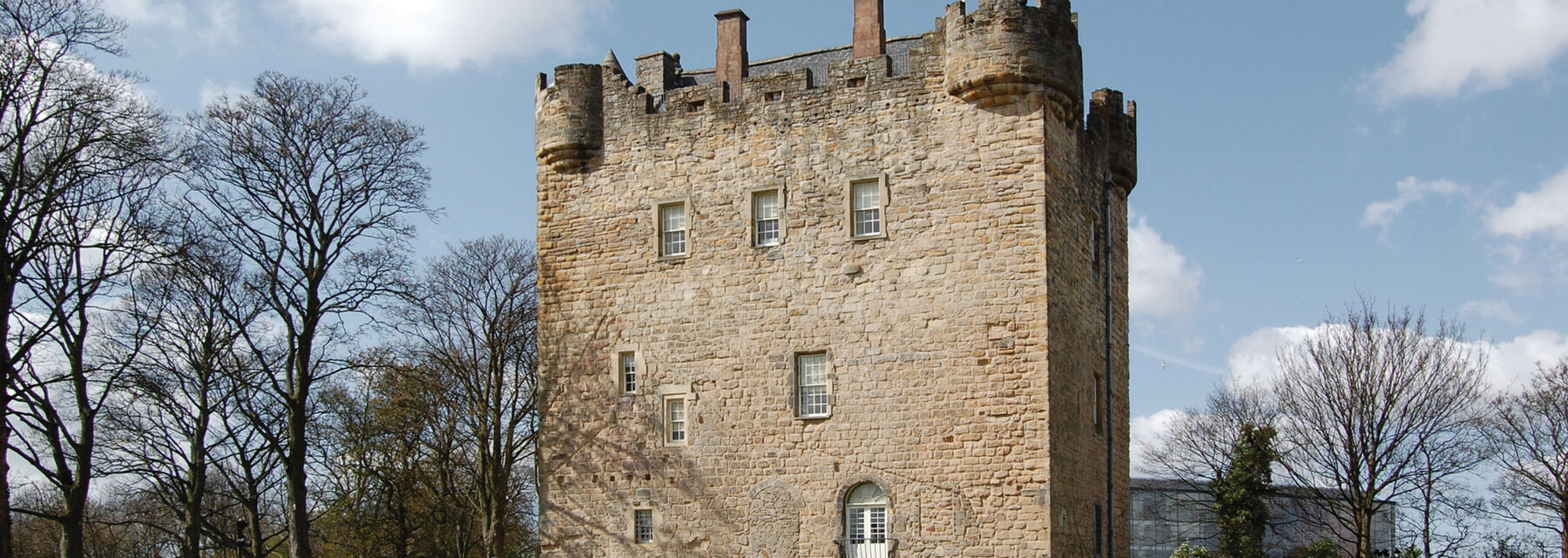 Exterior of Alloa Tower surrounded by bare trees in winter.