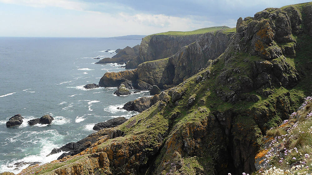 A rugged coastline, with waves crashing against cliffs at St Abb's Head.