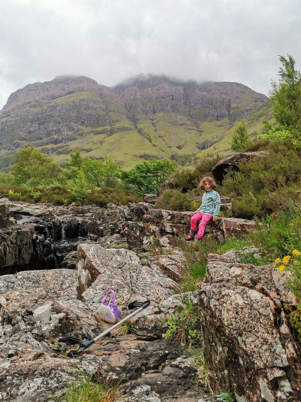 Small girl sitting on rocks in Glencoe