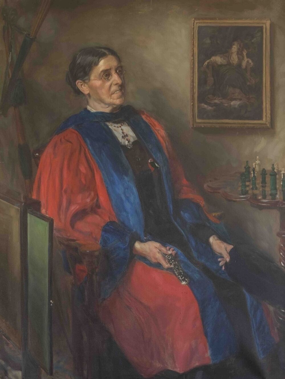 A painted portrait of an older woman in glasses with her greying hair pulled back into a bun, sitting in a chair in front of a small table with a game of chess set up on it. She's wearing a red scholar's gown with blue fabric lining the cuffs and seams.