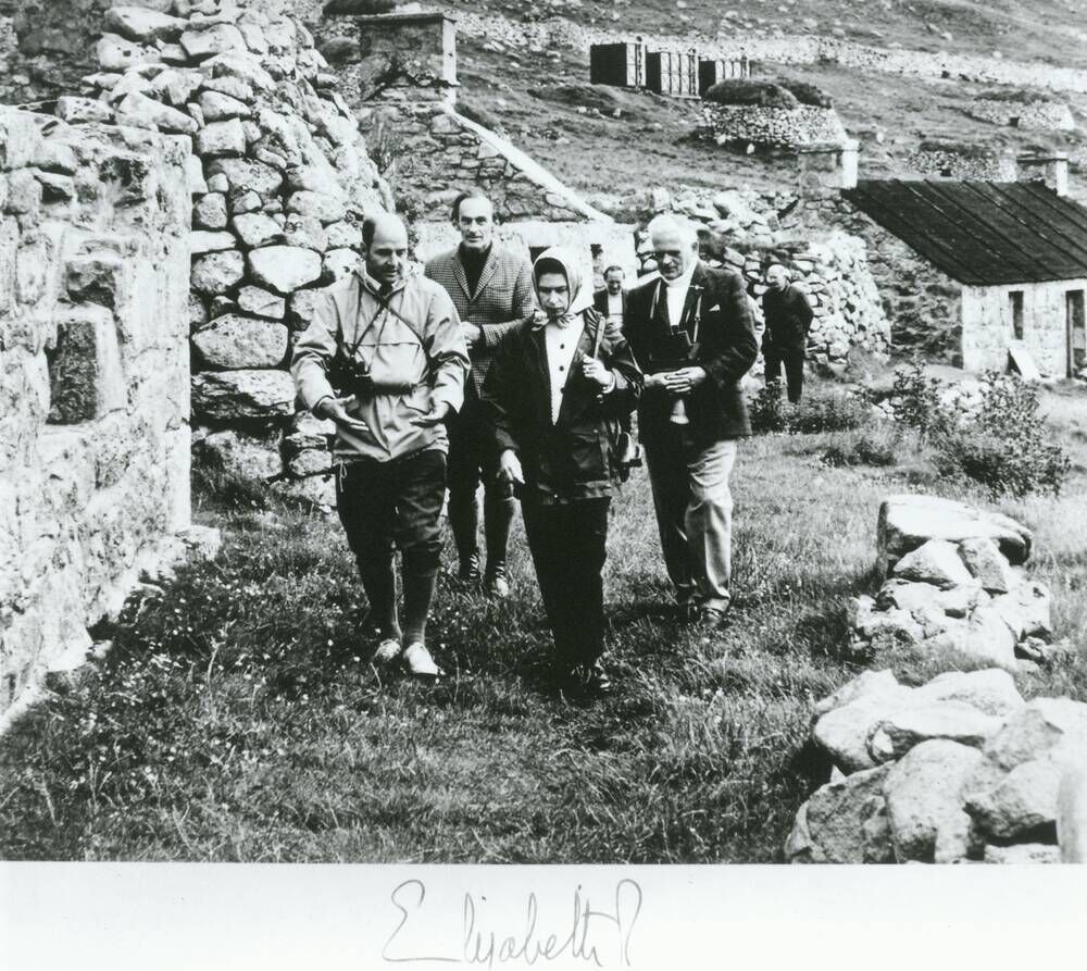 The Queen and a Trust delegation walk among the deserted cottages on St Kilda