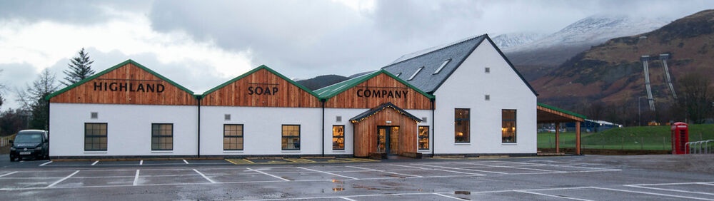 The Highland Soap Company's workshop with views of snow-capped Ben Nevis behind and to the right of the building.