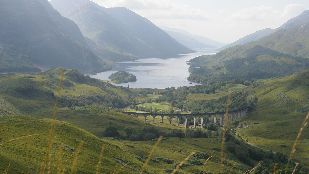 Looking down across the Glenfinnan Viaduct, the Glenfinnan Monument and Loch Shiel.