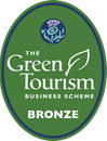 A green oval badge showing the Visit Scotland thistle logo and 'The Green Tourism Business Scheme' logo with the words: bronze in capital letters.